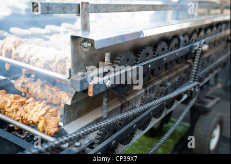 Un barbecue au charbon de bois avec l'entreprise appelée Roastmaster à Londres UK, système qui tourne les brochettes Banque D'Images