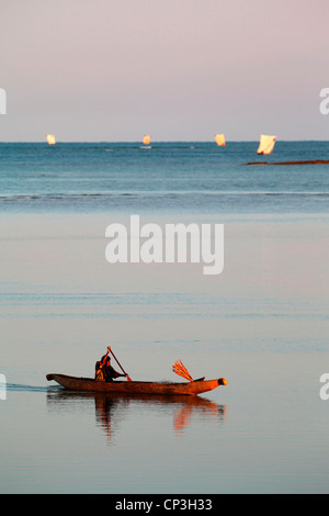 Un pêcheur Vezo rentrant du travail son canoë kayak chez dans Belo-Sur-Mer, Madagascar, Afrique de l'Ouest, au lever du soleil. Banque D'Images