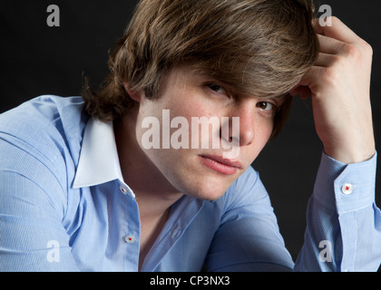 Headshot couleur de modèle masculin wearing blue shirt photographié contre fond noir Banque D'Images