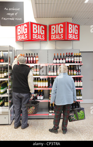 Vieil Homme et femme retraités shopping dans un supermarché de l'allée du vin. Banque D'Images