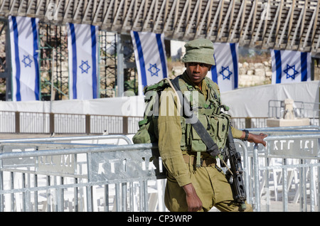 Soldat israélien au garde barrière sur Memorial Day avec des drapeaux israéliens en arrière-plan. Mur ouest. Vieille ville de Jérusalem. Israël. Banque D'Images