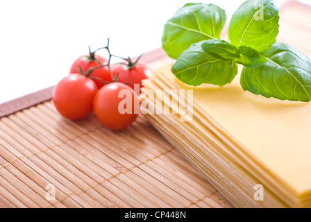 Les feuilles de lasagne avec sherry tomates et basilic frais. Banque D'Images