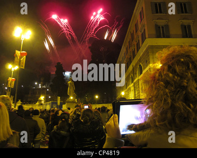 Femme à l'aide d'ipad pour photographie d'artifice sur la Piazza del popolo à Rome Italie Banque D'Images