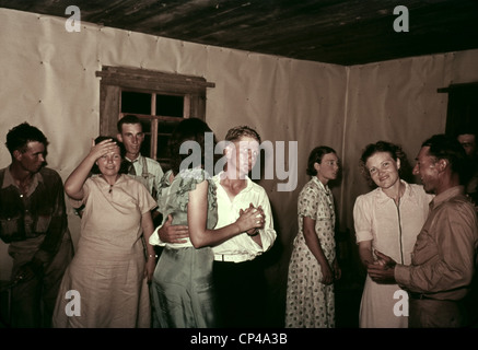 Square dance en milieu rural maison à McIntosh Comté de l'Oklahoma. Ils dansent dans un intérieur simple avec des murs couverts de papier de boucher. Ca. Banque D'Images