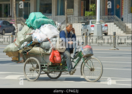 Un véhicule transportant des marchandises voyageant le long d'une des principales routes de Datong avec le propriétaire parle sur son téléphone mobile. Banque D'Images