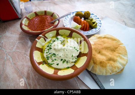 Masabacha houmous servi avec pain pita, légumes et boules de falafel. Sauce épicée peut être ajouté à ce favori du Moyen-Orient. Banque D'Images