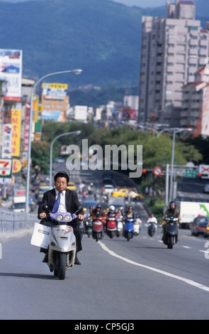 Taiwan, Taipei, le trafic, l'homme en scooter en tailleur, l'un des modes de transport les plus populaires dans le centre de Taipei. Banque D'Images
