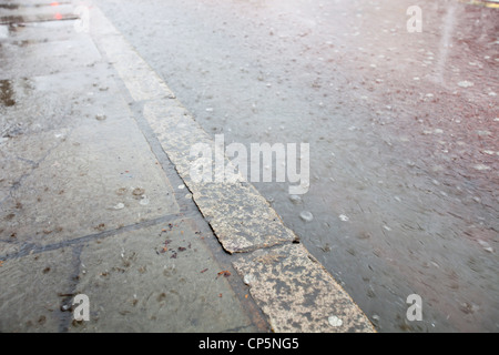 La pluie torrentielle inonde les gouttières d'un orage dans la région de Kings Cross, London, UK. Banque D'Images