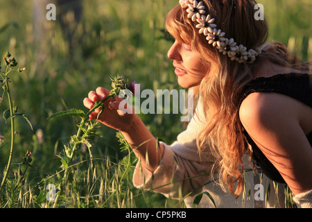 Jeune femme de 25 ans sent une fleur sauvage Banque D'Images