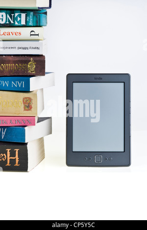 E-reader Kindle avec une grande pile de livres. Banque D'Images