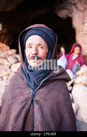 Un berger berbère qui sortent d'une grotte où son troupeau a l'abri pour la nuit dans l'Anti Atlas du Maroc. Banque D'Images