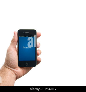 Hand holding Apple iPhone avec logo de Facebook Banque D'Images