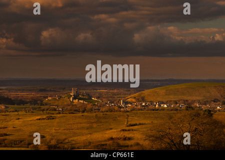 La fin de l'après-midi vue du château de Corfe et village voisin vu depuis le village voisin de Kingston dans le Dorset, UK. Banque D'Images