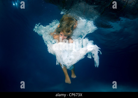 Une jeune femme avec de grands cheveux de poser dans un pool underwater Banque D'Images