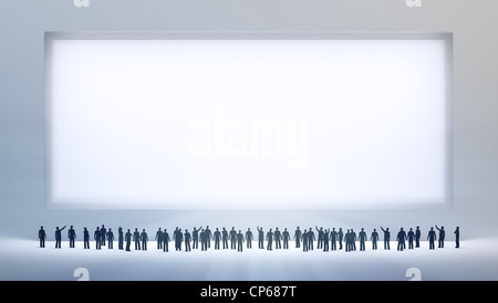 Un petit groupe de personnes regardant un vide ad conseil ou peinture Banque D'Images