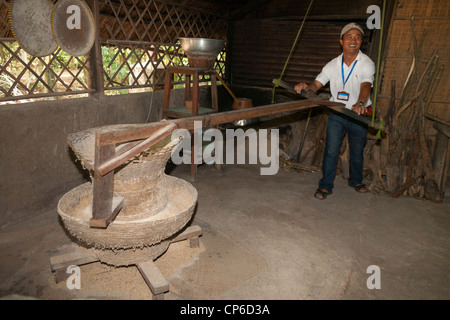 À l'aide d'une machine à l'homme primitif pour retirer les cosses de riz, Ben Dinh, Cu Chi, près de Ho Chi Minh Ville (Saigon), Vietnam, Banque D'Images