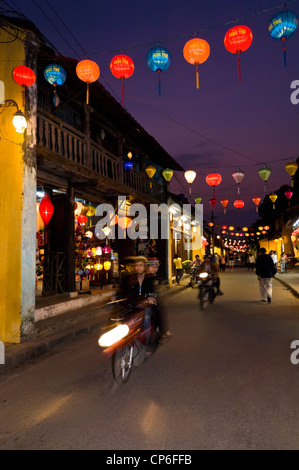 Paysage urbain vertical le long d'une route traditionnelle décorée à Hoi An avec des lanternes pour la fête du Têt éclairées la nuit, au Vietnam. Banque D'Images