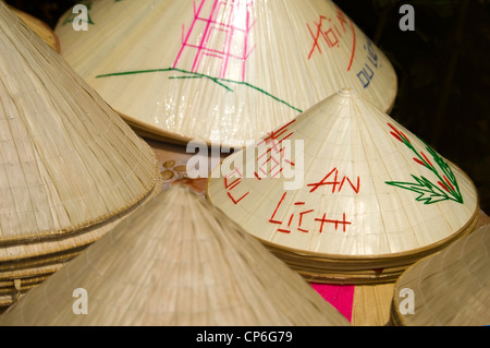 Close up horizontale de tas de nón lá, la non, le chapeaux de paille coniques traditionnels portés par de nombreux au Vietnam. Banque D'Images