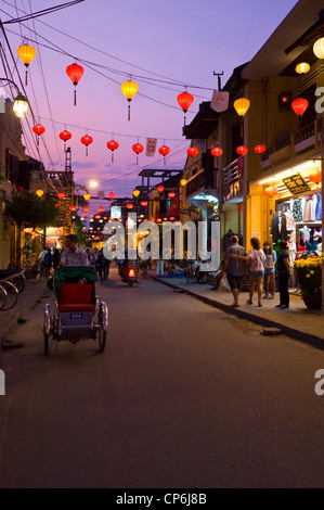 Vue verticale le long d'une route traditionnelle à Hoi An décorées avec des lanternes éclairées la nuit. Banque D'Images