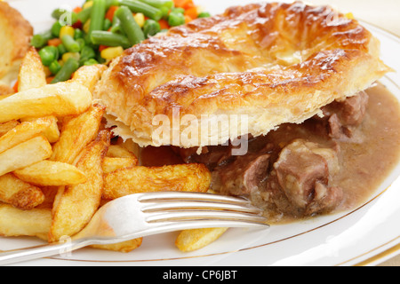 Un repas d'un steak and kidney pie avec des croustilles de pommes de terre frites et légumes mixtes Banque D'Images