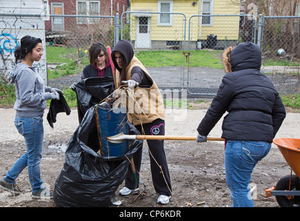 Detroit, Michigan - les lycéens et étudiants bénévoles nettoyer la corbeille dans une ruelle. Banque D'Images