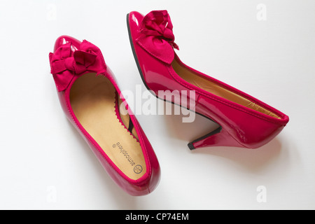 Rose brillant paire de chaussures à talon haut brevet avec noeud sur l'avant isolé sur fond blanc Banque D'Images