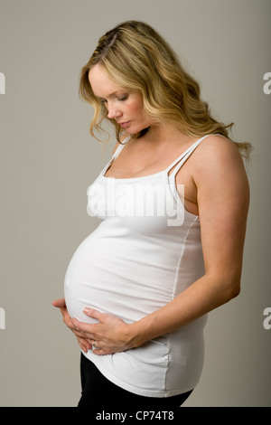 Le portrait d'une femme enceinte de neuf mois, tenant sa bosse. Banque D'Images