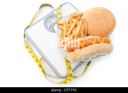 Les aliments d'engraissement sur une balance avec un ruban de mesure, y compris les copeaux et burger hot dog Banque D'Images