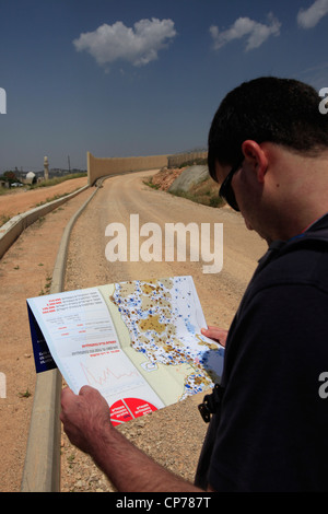 Un activiste israélien de gauche regardant une carte marquée avec des colonies juives sur le site de construction de la barrière de séparation de Cisjordanie, mult par Israël dans le village palestinien d'al Walaja en Cisjordanie Israël Banque D'Images