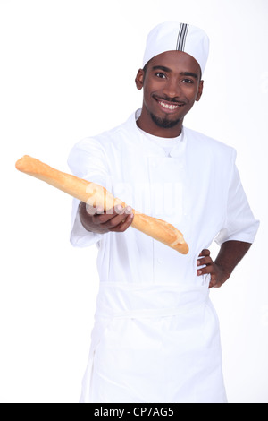 Jeune africain baker tenant un pain frais Banque D'Images