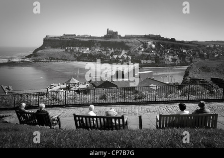 Les touristes tout en observant le soleil à Whitby, à la recherche de l'autre côté de la baie avec l'abbaye dans la distance. Le Yorkshire, en Angleterre. Banque D'Images