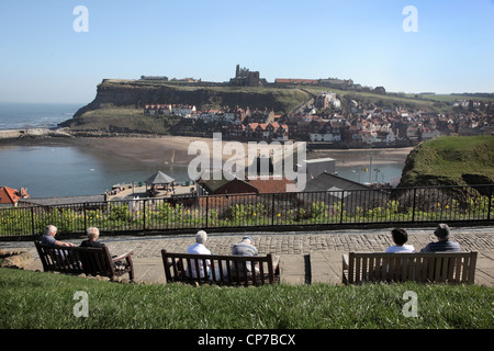 Les touristes tout en observant le soleil à Whitby, à la recherche de l'autre côté de la baie avec l'abbaye dans la distance. Le Yorkshire, en Angleterre. Banque D'Images