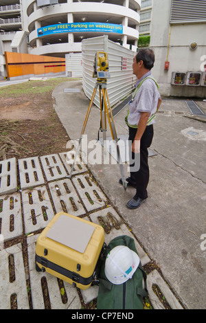 Un géomètre au travail avec station Total instrument d'arpentage à Singapour Banque D'Images