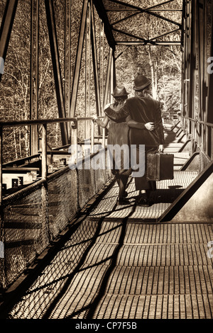 Un couple de vagabond va à un vieille valise sur un vieux pont de chemin de fer Banque D'Images