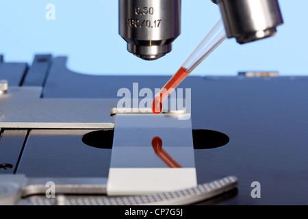 Photo d'un microscope de laboratoire avec un échantillon de sang sur une lame de verre. Banque D'Images