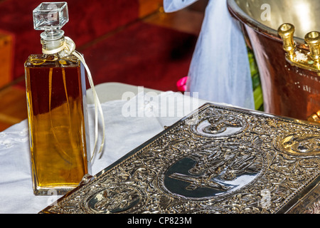 Bouteille d'huile, la police et le saint livre à cérémonie de baptême Banque D'Images