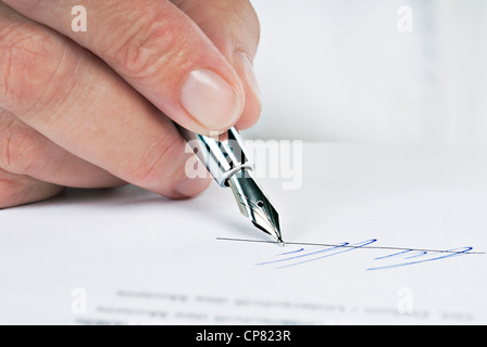 Close Up of a hand avec stylo et signer un document. Banque D'Images