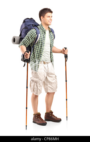 Portrait de hiker with backpack holding bâtons et posant isolé sur fond blanc Banque D'Images