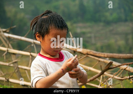 Un basha (Miao) hommes jeune garçon avec des hairstyle jouant, le sud de la Chine Banque D'Images