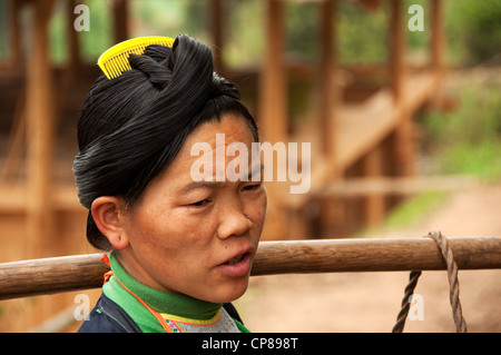 Un basha (Miao) hommes femme adultes transportant des marchandises sur ses épaules, le sud de la Chine Banque D'Images