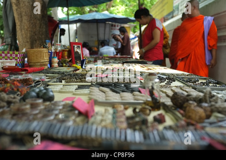 Une sélection de plats thaïlandais et de protection amulettes religieuses l'imagerie bouddhique en vente sur un marché à Bangkok près de Wat Mahathat temple. Banque D'Images