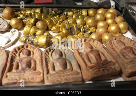Une sélection de plats thaïlandais et de protection amulettes religieuses l'imagerie bouddhique en vente sur un marché à Bangkok près de Wat Mahathat temple. Banque D'Images