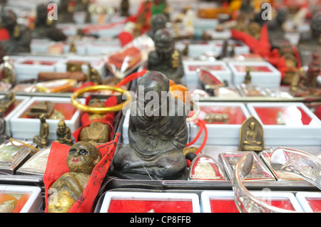 Une sélection de plats thaïlandais et de protection amulettes religieuses l'imagerie bouddhique en vente sur un marché à Bangkok près de Wat Mahathat temple. Banque D'Images