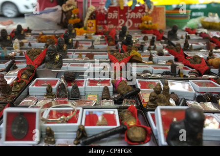 Une sélection de plats thaïlandais et de protection amulettes religieuses l'imagerie bouddhique en vente sur un marché à Bangkok près de Wat Mahathat temple. Banque D'Images