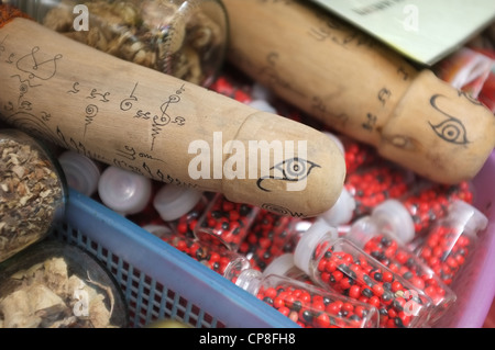 Une sélection de plats thaïlandais et de protection amulettes religieuses l'imagerie bouddhique en vente sur un marché à Bangkok près de Wat Mahathat temple. Banque D'Images