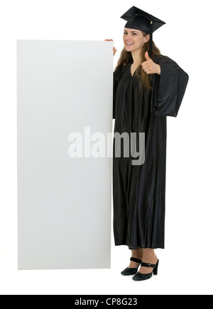 L'obtention du diplôme student holding blank billboard et showing Thumbs up Banque D'Images