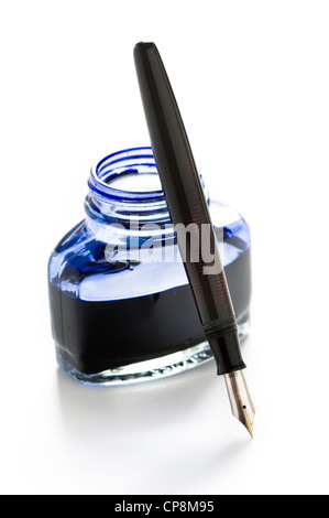 Un stylo plume appuyée sur une bouteille d'encre bleue isolé sur fond blanc Banque D'Images