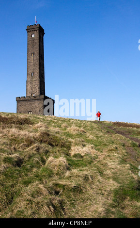 Walker passant tour Peel, Holcombe Hill, au-dessus de Ramsbottom, West Pennines, Greater Manchester / anche,UK Banque D'Images