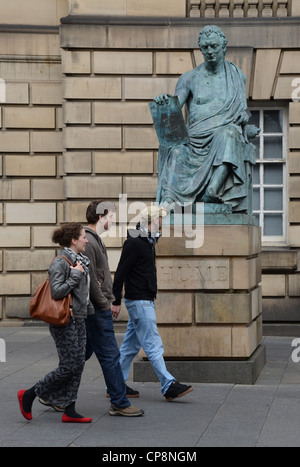 Les piétons se promener par la statue de David Hume sur la High Street à Édimbourg. Banque D'Images