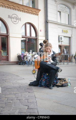 Un homme musicien ambulant à jouer de la guitare à l'avant du Hard Rock Cafe de la place du marché, Cracovie, Pologne. Banque D'Images